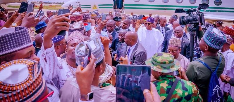 Buhari surrounded by a heavy thronged of his people who gave him a rousing welcome on his arrival in Nigeria on Monday after power handover. 