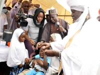 *  Officials administering the vaccines to a child at the Flag-off ceremony.