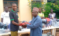 * Sokoto State Coordinator of NDE, Malam Ibrahim Faisal Audu, presenting empowerment tools to some of the EBTS beneficiaries in the State. Photo by: Ankeli Emmanuel, Sokoto.